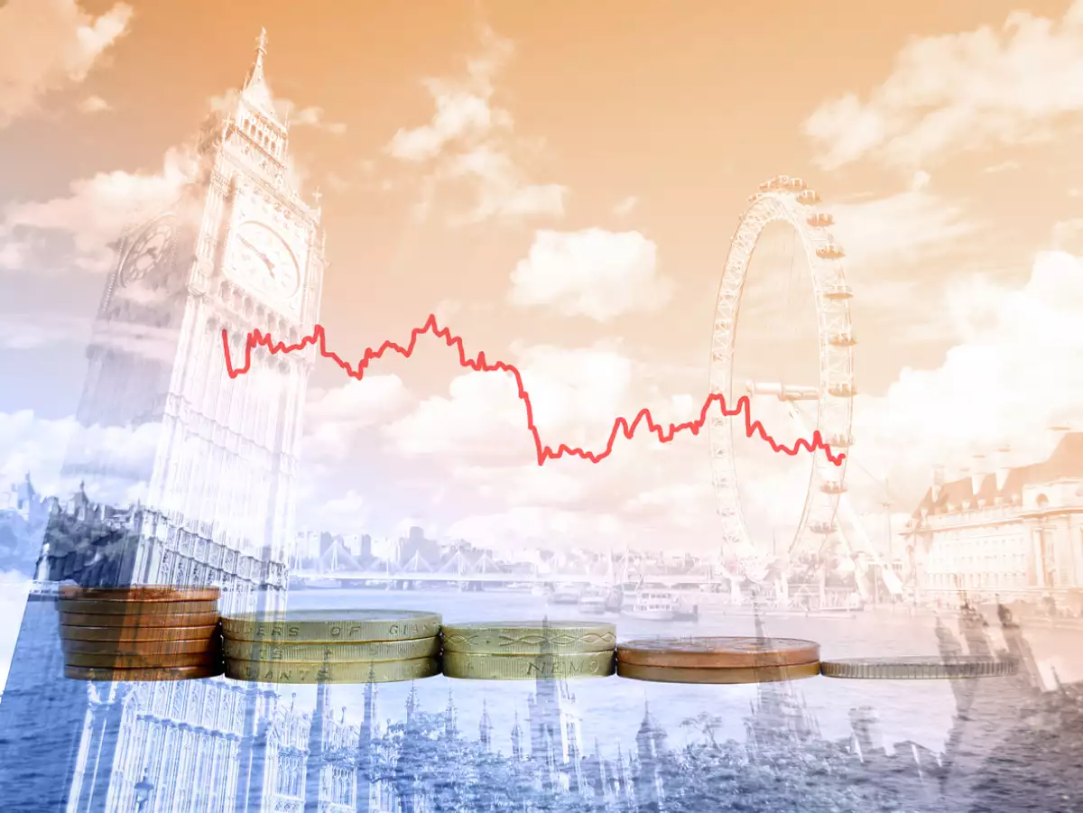 Piles of British coins with decreasing graph of UK currency