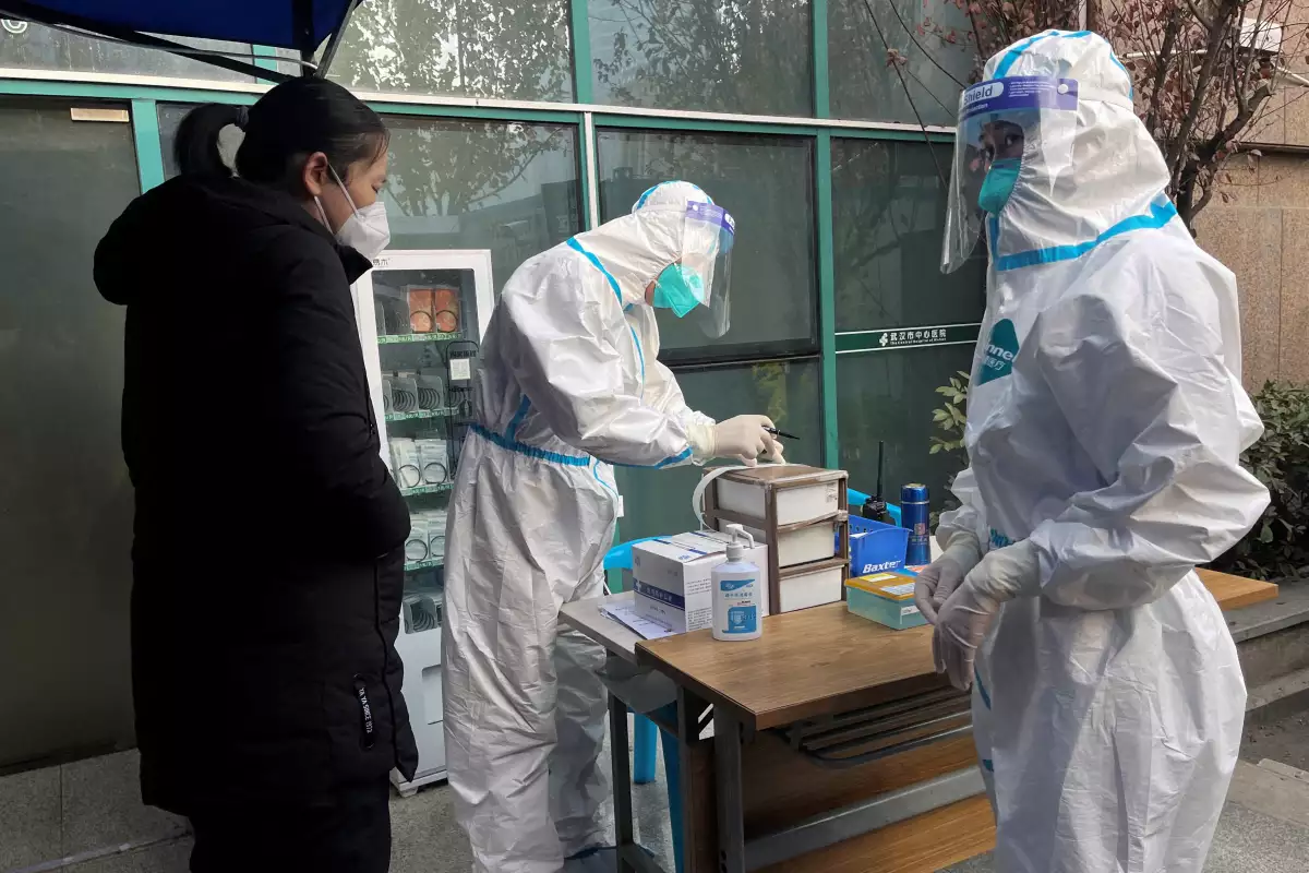 Un trabajador médico con traje protector registra información para un paciente en la entrada de la clínica de fiebre del Hospital Central de Wuhan, en medio del brote de la enfermedad por coronavirus (COVID-19), en Wuhan, provincia de Hubei, China, 31 de diciembre de 2022