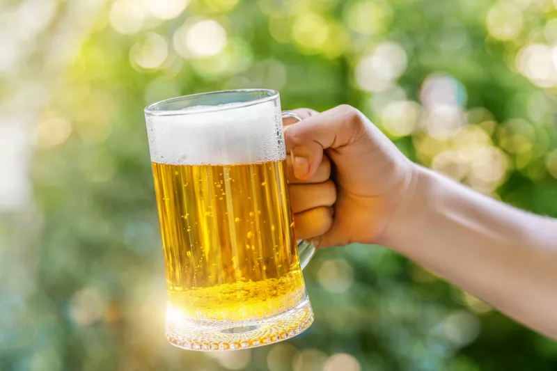 Man holds a glass of beer.