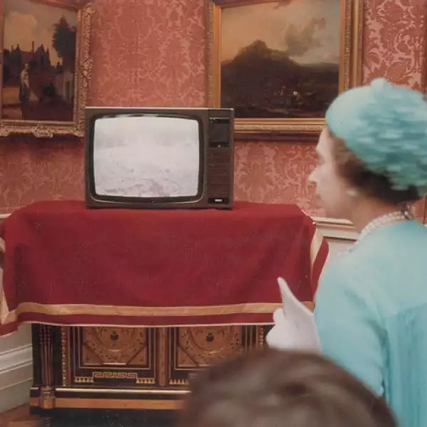 La reina Isabell II observa en una televisión las imágenes de las personas en espera de ver a los príncipes Diana y Carlos.