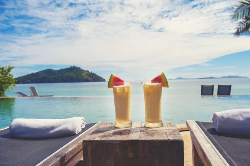 Dos bebidas refrescantes con el mar azul de fondo 
