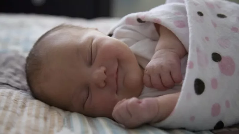 un recien nacido dormido y sonriendo