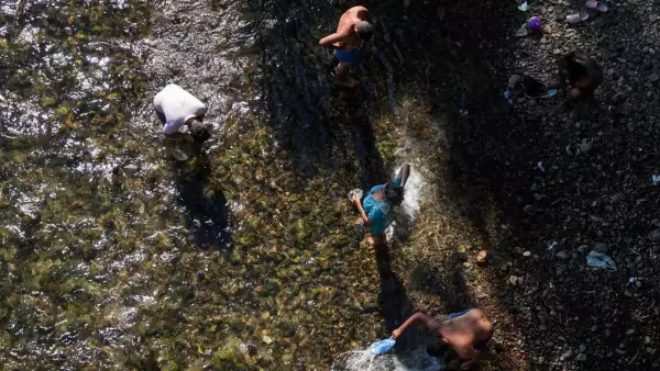 Migrantes toman un baño en el Río Ostuta previo a continuar su recorrido a Santiago Niltepec.