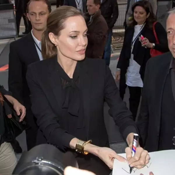 jolie da un autografo con la mano izquierda