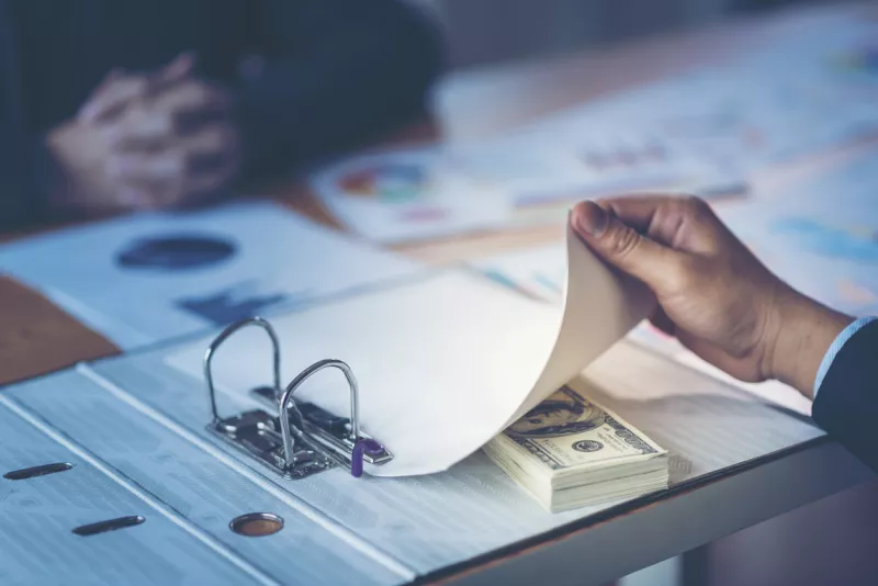 Businessman receive money in the envelope offered in file - anti bribery and corruption concepts