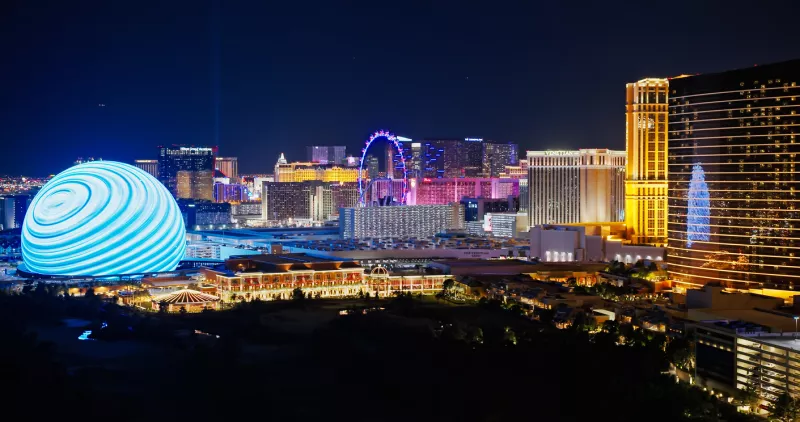 Foto panorámica de Las Vegas por la noche con la ciudad completamente iluminada.