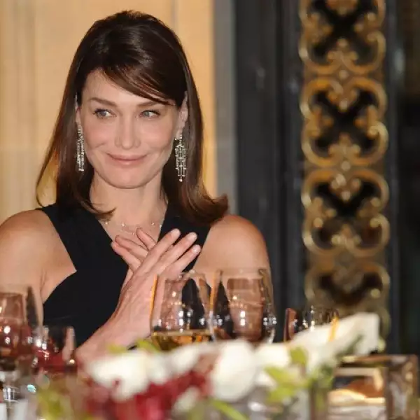 Con una expresión de picardía, Carla Bruni sonrió al mismo tiempo que se frotaba las manos.