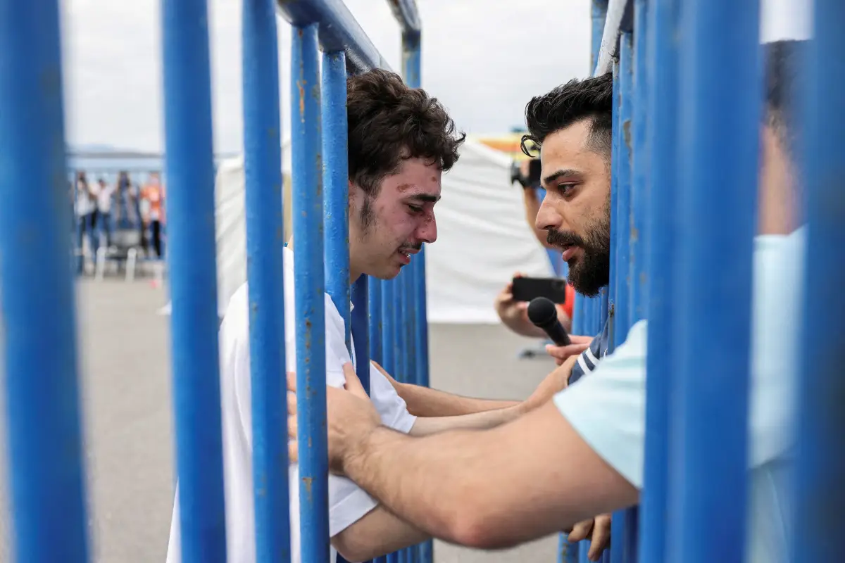 El sobreviviente sirio Mohammad, de 18 años, que fue rescatado con otros refugiados y migrantes en mar abierto frente a Grecia después de que su barco volcara, llora mientras se reúne con su hermano Fadi, que vino a reunirse con él desde los Países Bajos, en el puerto de Kalamata, Grecia, el 16 de junio de 2023. REUTERS/Stelios Misinas