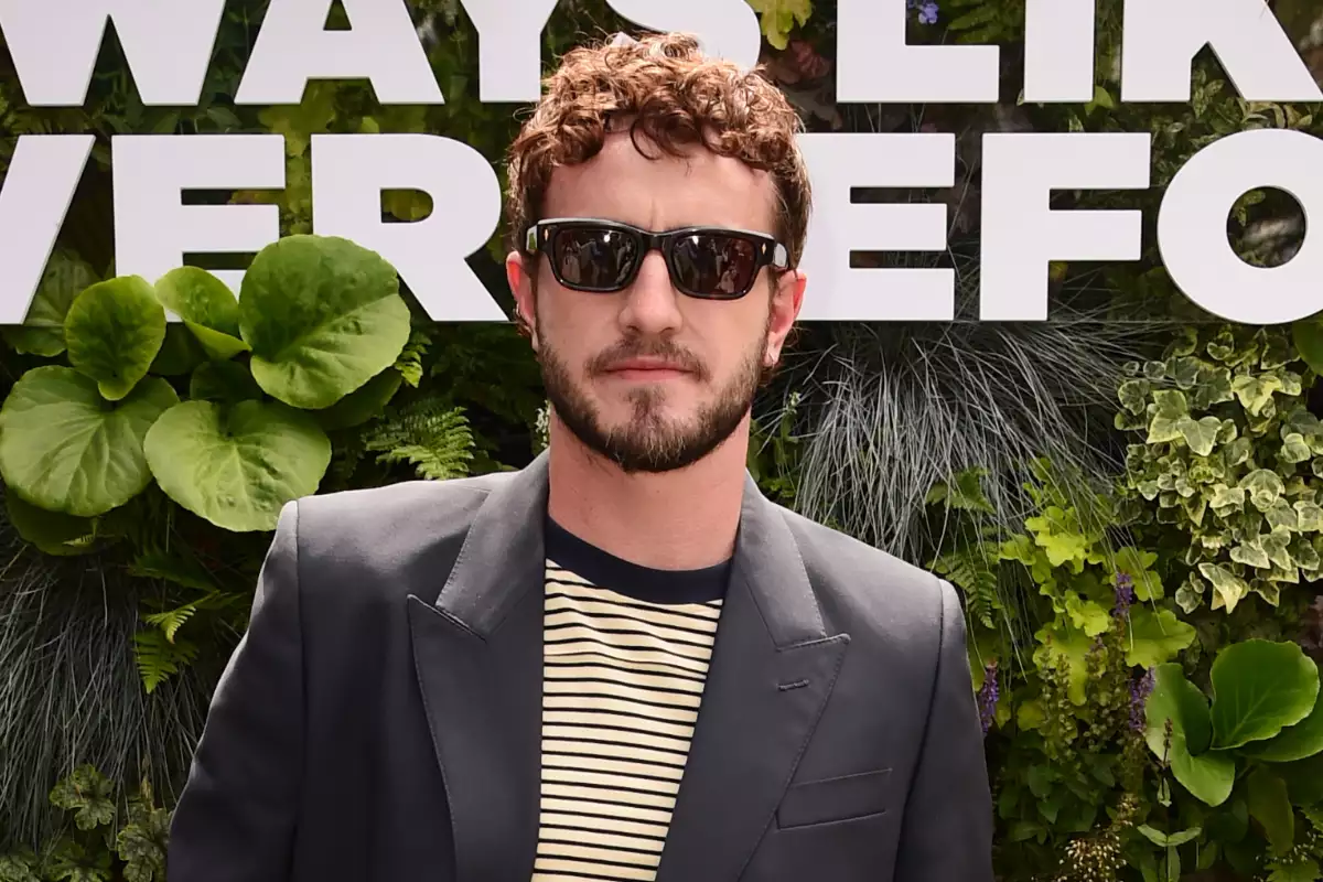 Foto de Paul Mescal con mud cut, lleva lentes oscuros, barba, playera a rayas y saco.