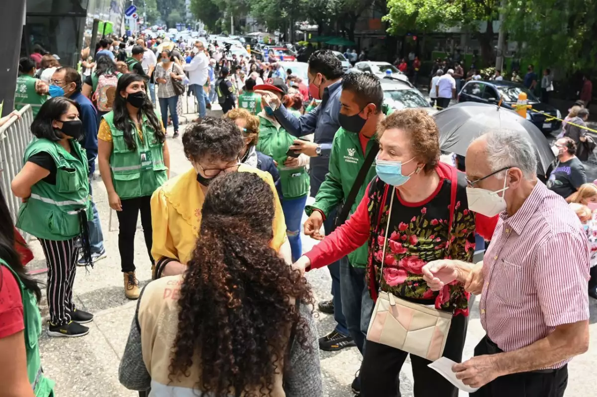 Una pareja de adultos mayores intenta entrar al centro de vacunación.