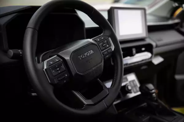 Foto del interior renovado de la Nueva Toyota Hilux 2027 donde destaca el nuevo volante y pantalla central.