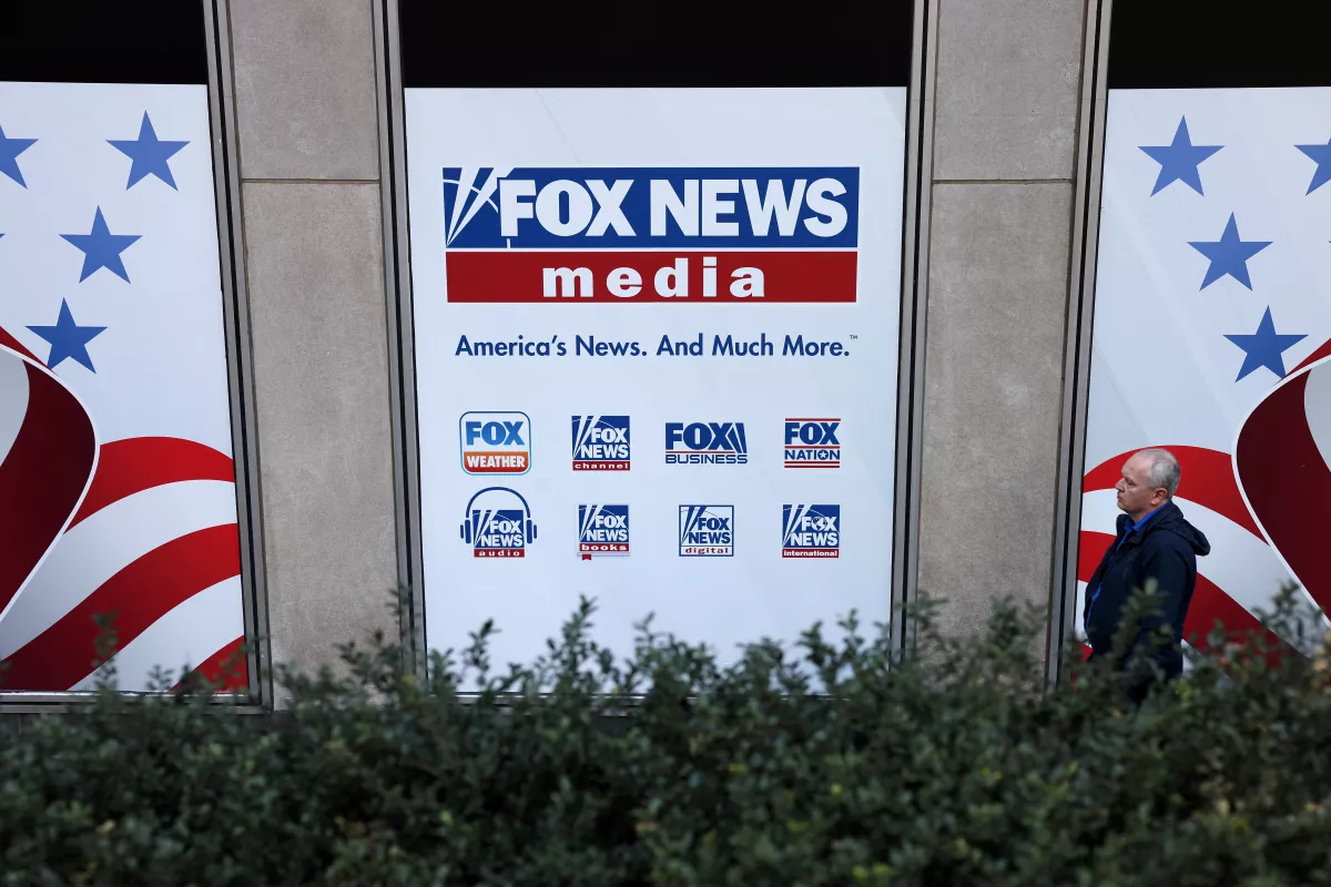 FILE PHOTO: A person walks by Fox News signage posted on the News Corporation building in New York City