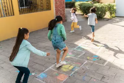 Child friends playing hopscotch outdoors