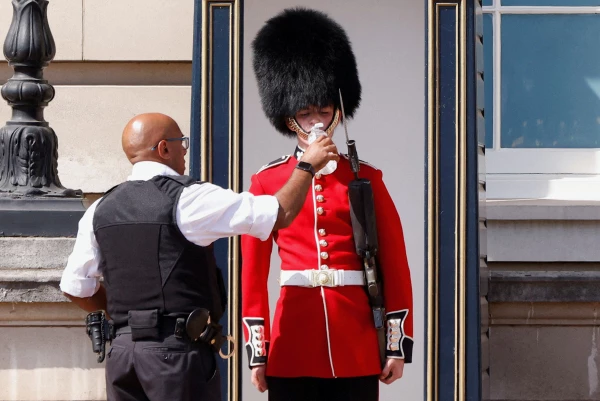 Un miembro de la Guardia de la Reina recibe agua para beber durante el clima cálido, en las afueras del Palacio de Buckingham en Londres, Gran Bretaña.