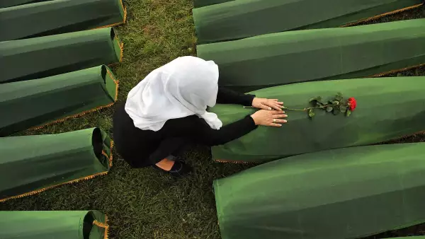 Una mujer musulmana bosnia, sobreviviente de la masacre de Srebrenica en 1995, llora por el ataúd de su pariente, en el cementerio conmemorativo en el pueblo de Potocarion, cerca de la ciudad oriental de Srebrenica, el 10 de julio de 2013. El 30 aniversario de la masacre de Srebrenica por parte de las fuerzas serbias de Bosnia tendrá lugar el 11 de julio de 2025