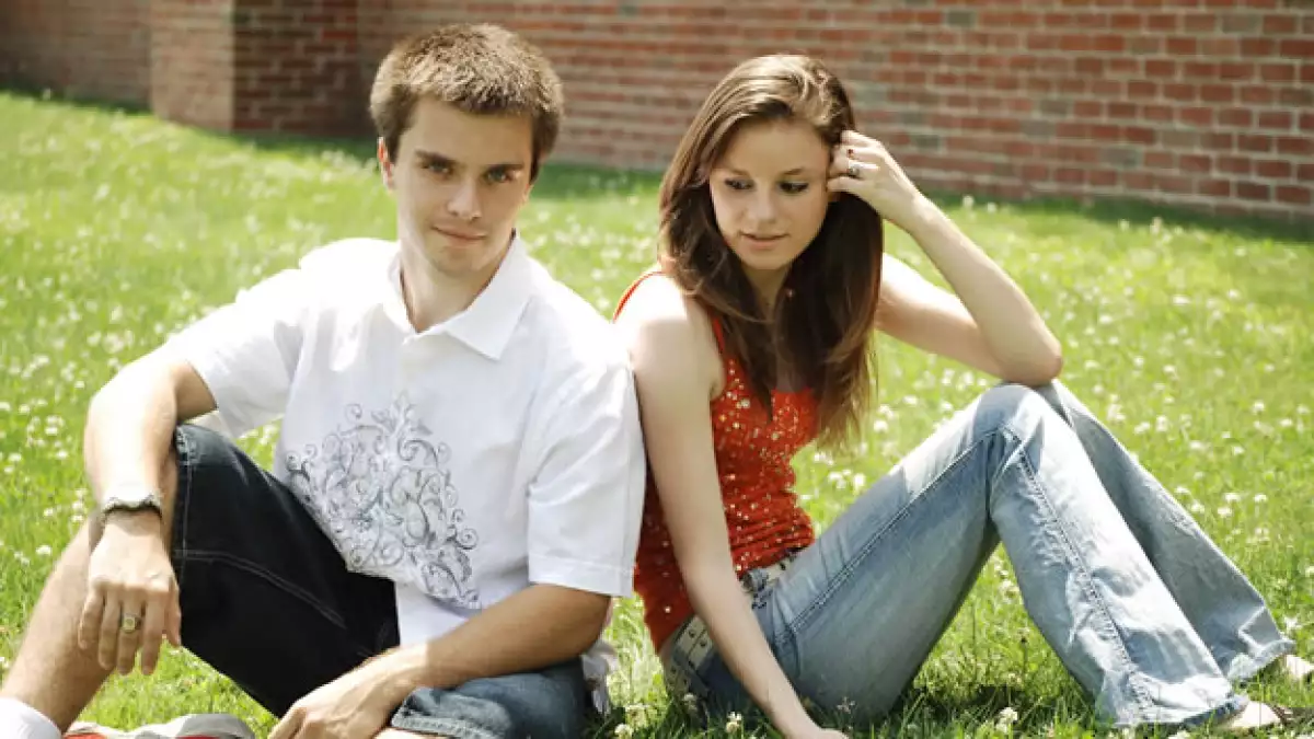 pareja de adolescentes sentados en el pasto