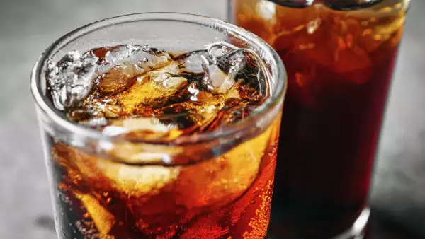 Cola soft drink with ice cubes, Close up of soda fizzy drink in Cold glass on gray background