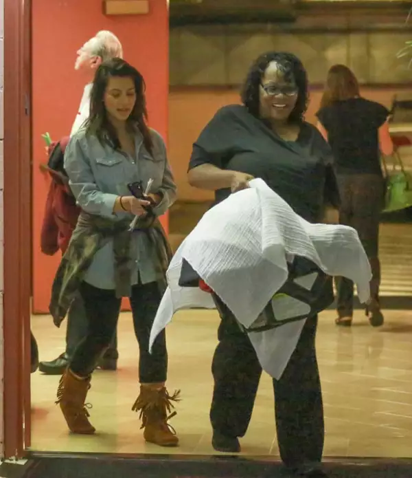 Kim lucía feliz. Aquí con la niñera que carga el bambineto de North.