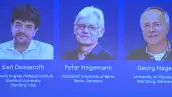 Tres fotos con fondo azul de tres hombres, dos con lentes. Karl, Peter y Georg, ganadores del Premio Nobel de Medicina 2026.jpg