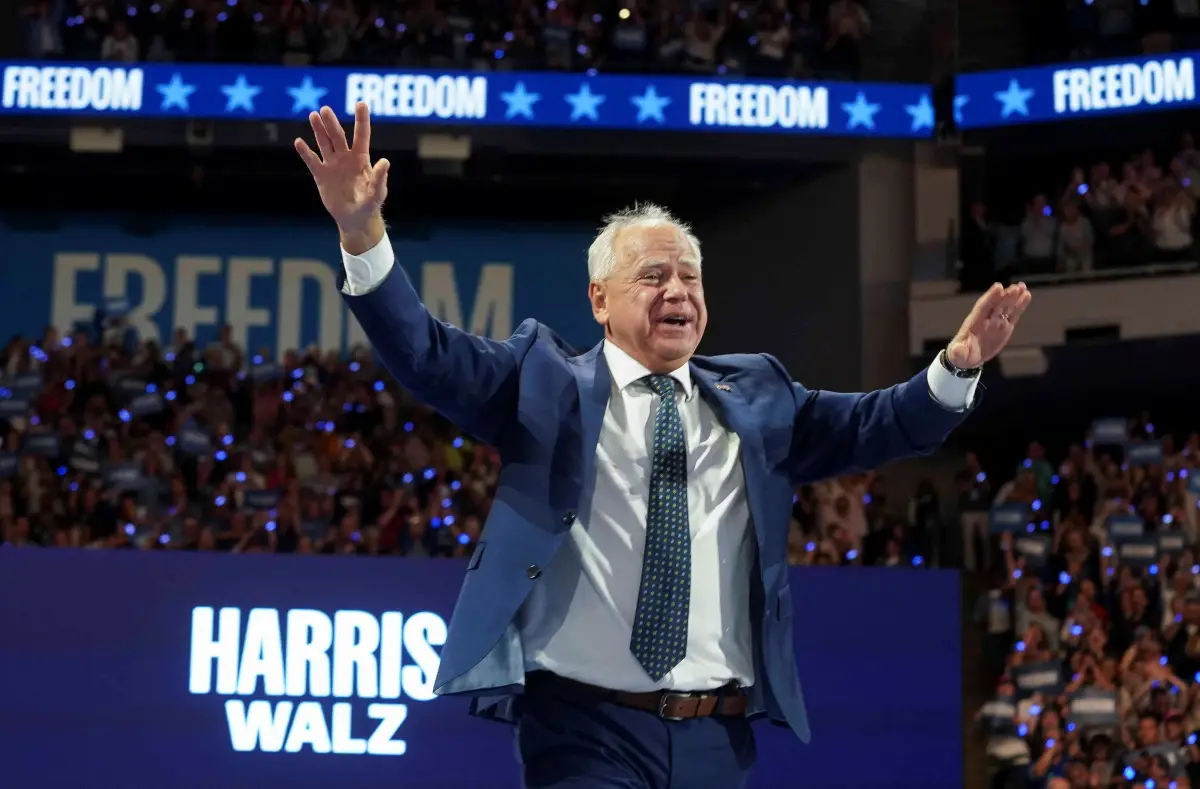 El candidato demócrata a la vicepresidencia, gobernador de Minnesota, Tim Walz, un hombre de más de 60 años, con cabello Branco, vestido con un traje azul, hace un gesto en un mitin de campaña en Milwaukee, Wisconsin, EE. UU., el 20 de agosto de 2024.