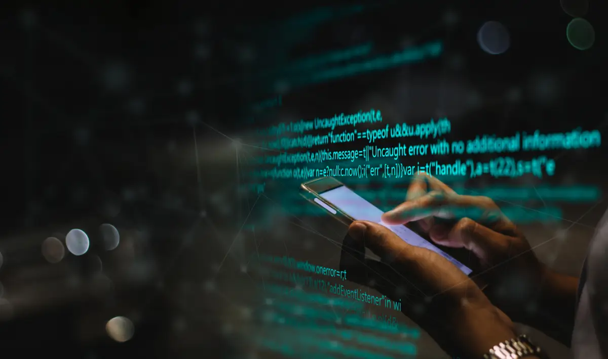 Mujer usa un teléfono con códigos de programación de fondo. 