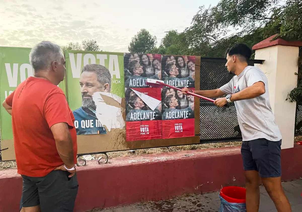 Los miembros del Partido Socialista Obrero (PSOE) pegan carteles electorales del primer ministro en funciones y líder socialista de España, Pedro Sánchez, junto a un cartel electoral del líder del partido Vox de extrema derecha de España, Santiago Abascal, antes de las elecciones anticipadas, en una calle de Ronda, España, el 19 de julio de 2023.