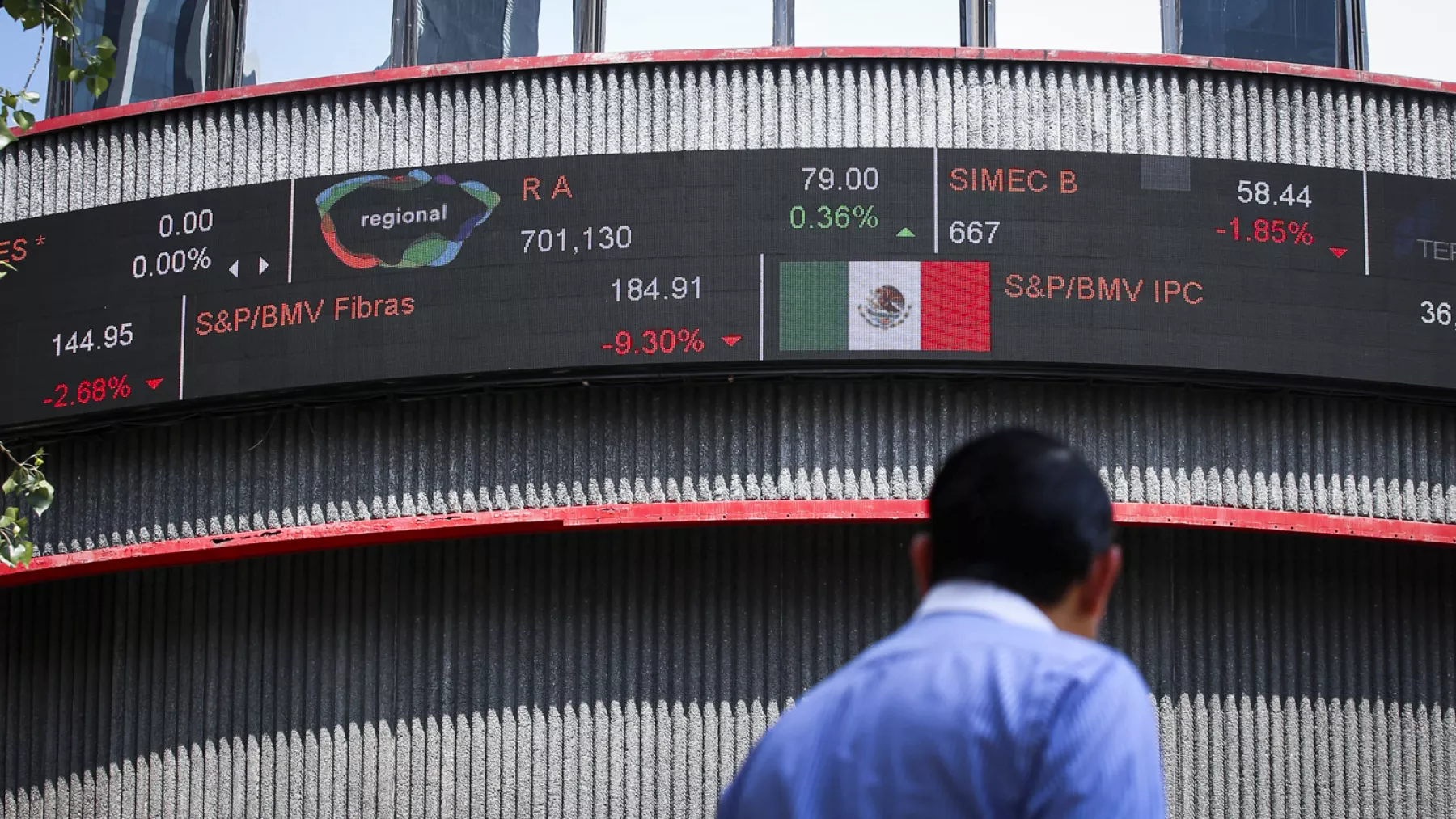 A pedestrian walks in front of the building of Mexico's stock exchange after Latin American stocks tanked amid continued concerns over the coronavirus disease (COVID-19), in Mexico City