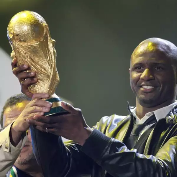 El futbolista francés Patrick Vieira sostiene la copa del Mundo durante el concierto de apertura.