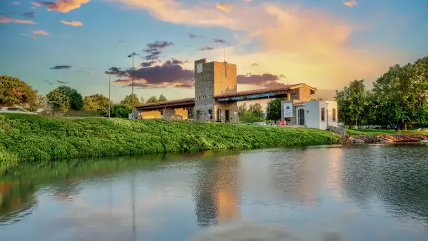 Se observa parte de un lago, en segundo plano: El Campanario y al fondo una puesta de sol.