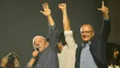 Lula da Silva levanta mano izquierda en la cual se observa la falta de su dedo meñique. Lo acompaña el vicepresidente.jpg