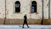 Una mujer camina fuera de St. El Convento de Iveron, que fue muy dañado por la artillería y los disparos durante las batallas por el aeropuerto local en el transcurso del conflicto ruso-ucrania, en Donetsk, una región controlada por Rusia de Ucrania, el 25 de febrero de 2025