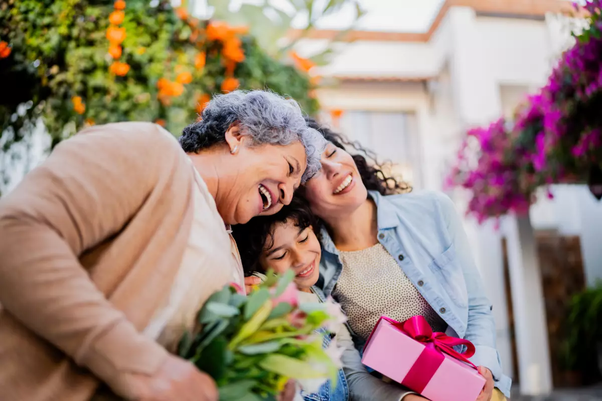 Family embraced and holding gifts outdoors