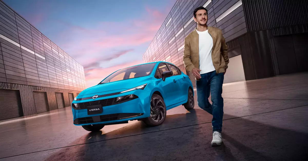 Foto del nuevo Nissan Versa 2026 estacionado entre dos edificios y con un joven caminando a su lado.