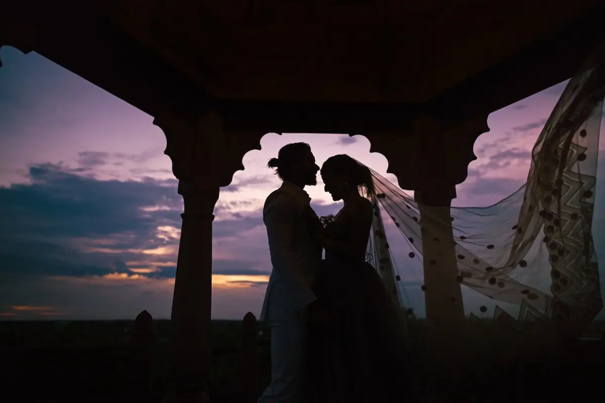 Una pareja a contraluz en el día de su boda. 