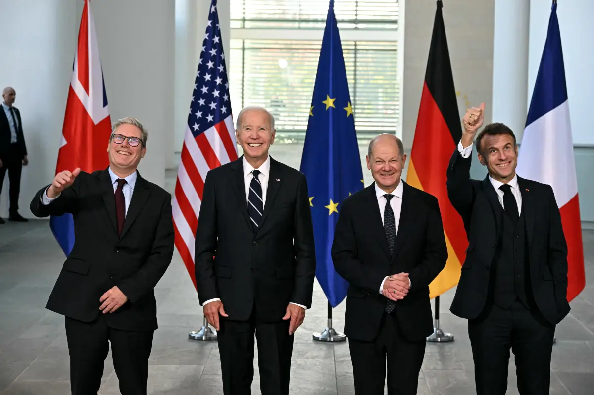 La imagen muestra sonrientes (de izquiera a derecha) al primer ministro británico Kier Stramer, el presidente estadounidense Joe Biden, al canciller alemán Olaf Scholz y al presidente de Francia, Emmanual Macron después de reunirse para discutir diversos asuntos. Detrás de ellos estan las banderas de Reino Unido, Estados Unidos, la Unión Europea, Alemania y Francia.