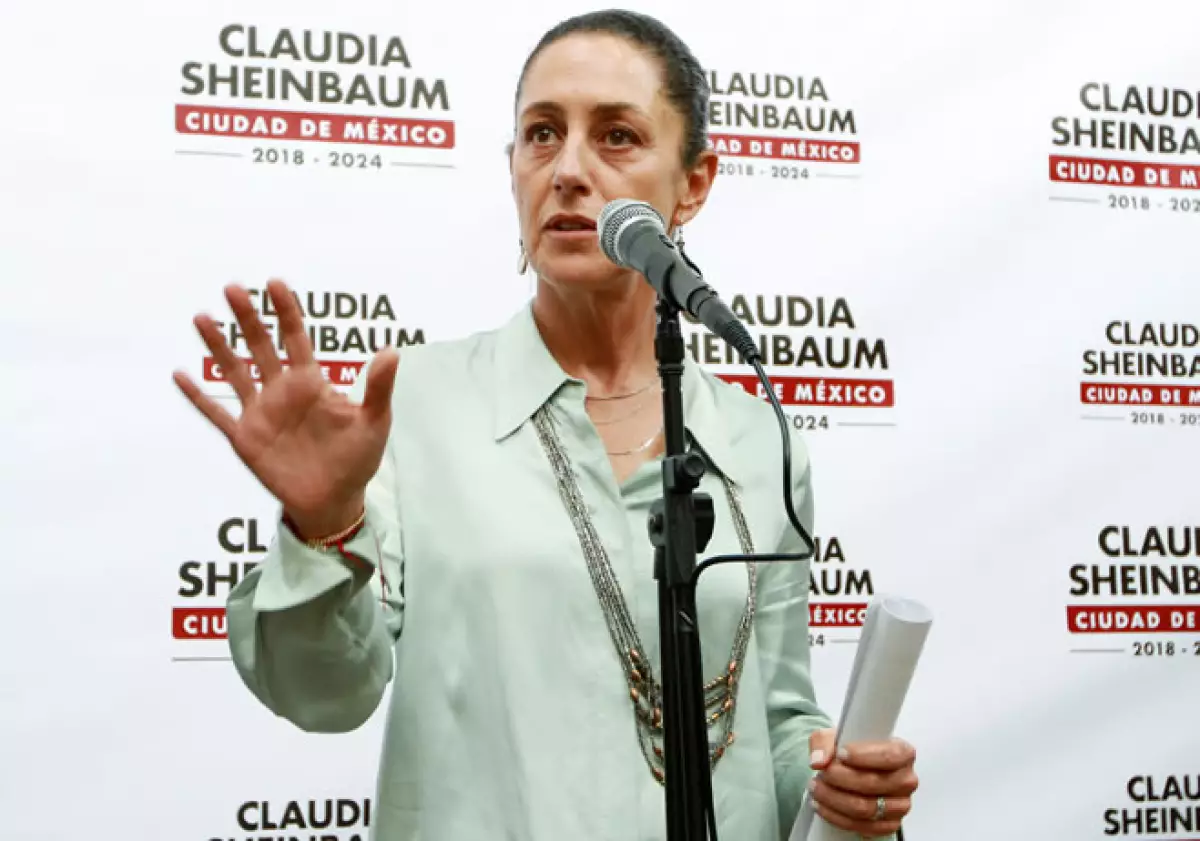 claudia sheinbaum hace un ademán con el que aparenta aclarar algo.