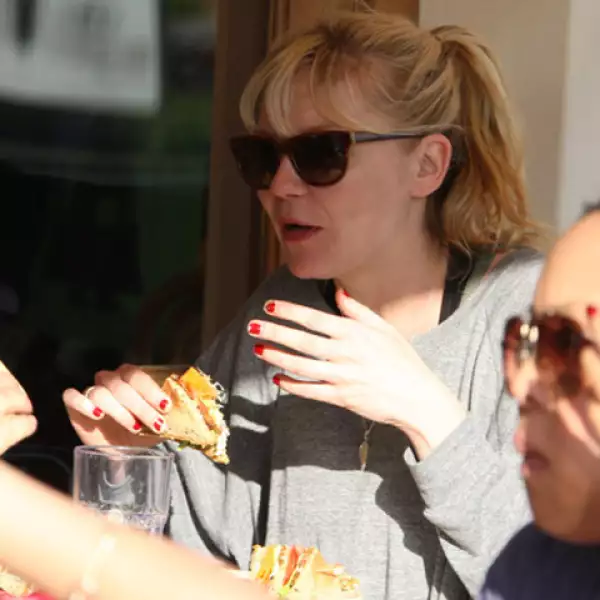 La bella actriz Kirsten Dunst se dejó envolver por las redes de un rico sandwich, mientras platicaba muy agusto con una amiga.