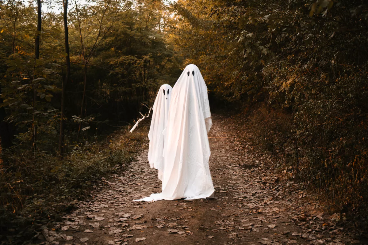 Foto de dos personas personas vestidas de fantasmas como disfraz de Halloween.