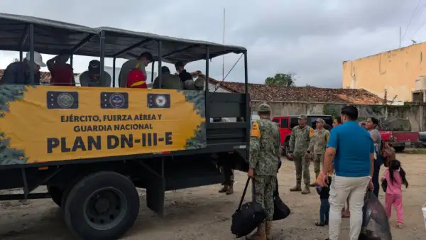 Un camión militar con letras que dicen Plan DN tres en donde militares ayudan a subir a tres adultos y una niña.jpg