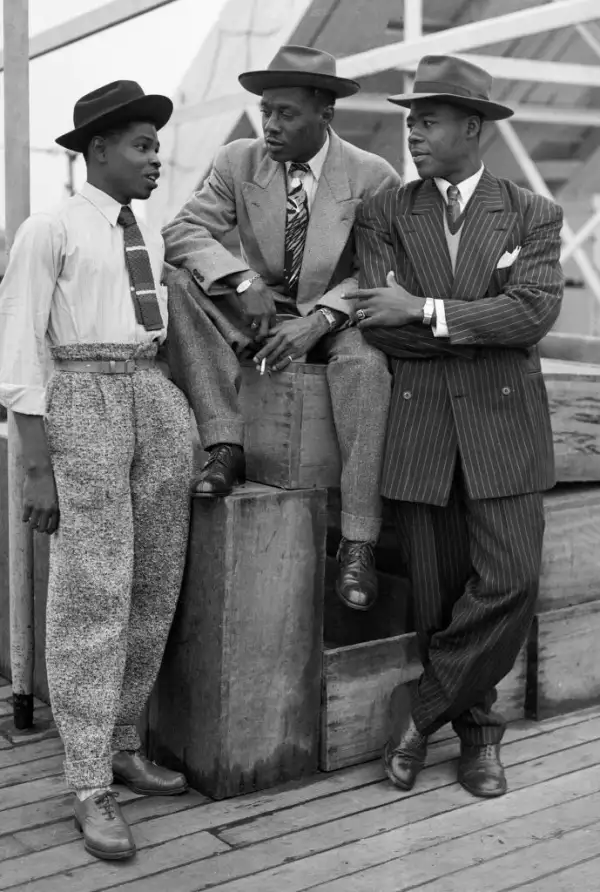 Tres hombres jóvenes afrodescendientes vestidos con zoot suits