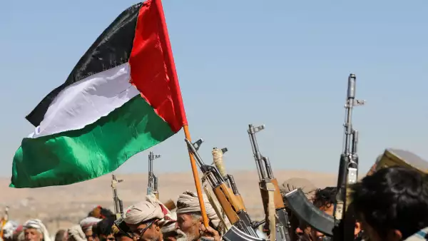 Los partidarios tribales de los hutíes de Yemen agitan una bandera palestina y sostienen sus armas de fuego durante una protesta por los recientes ataques liderados por Estados Unidos contra objetivos hutíes, cerca de Sanaa, Yemen, el 14 de enero de 2024.