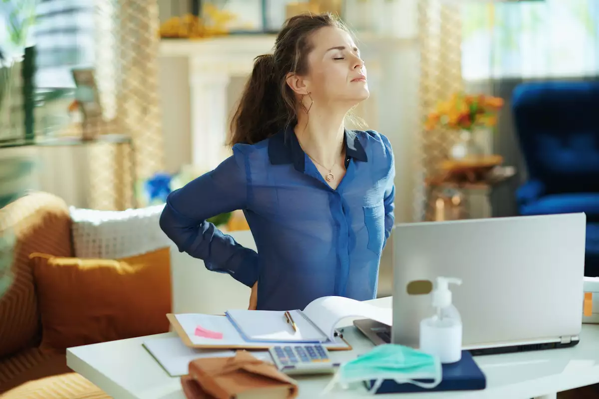 tired woman in modern house in sunny day having back pain