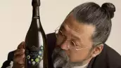 Foto del artista japonés Takashi Murakami observando de cerca la botella de Dom Pérignon que intervino con su diseño.