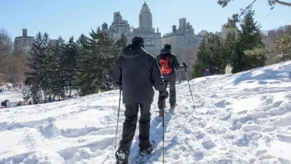 Una pareja sacó sus esquíes y calzado para la nieve para 'viajar' por Central Park, en Nueva York, mientras el sol dura este domingo.