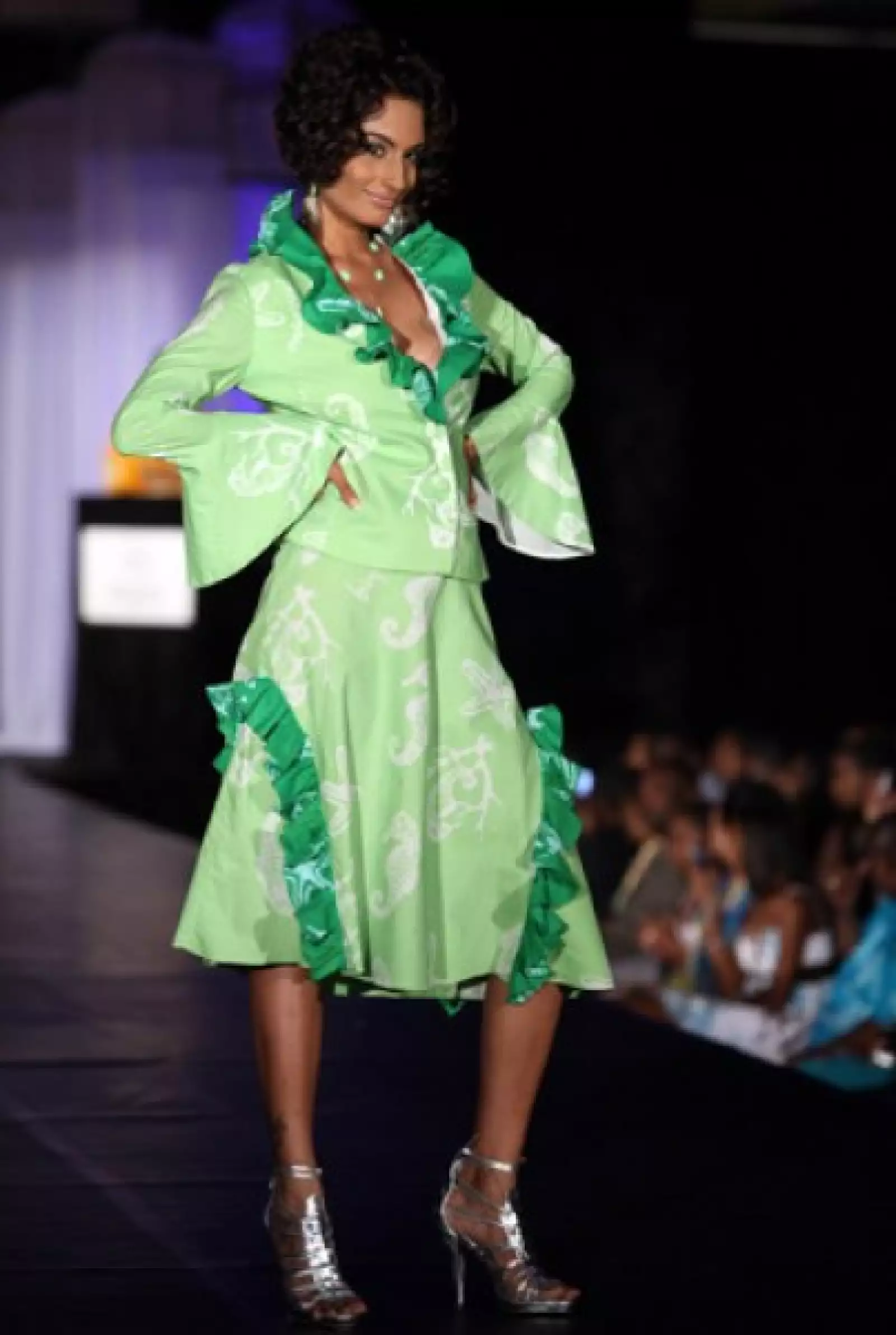 Ekta Chowdhry, de India, en un vestido verde con mangas acampanadas y algunos holanes en pecho y falda.