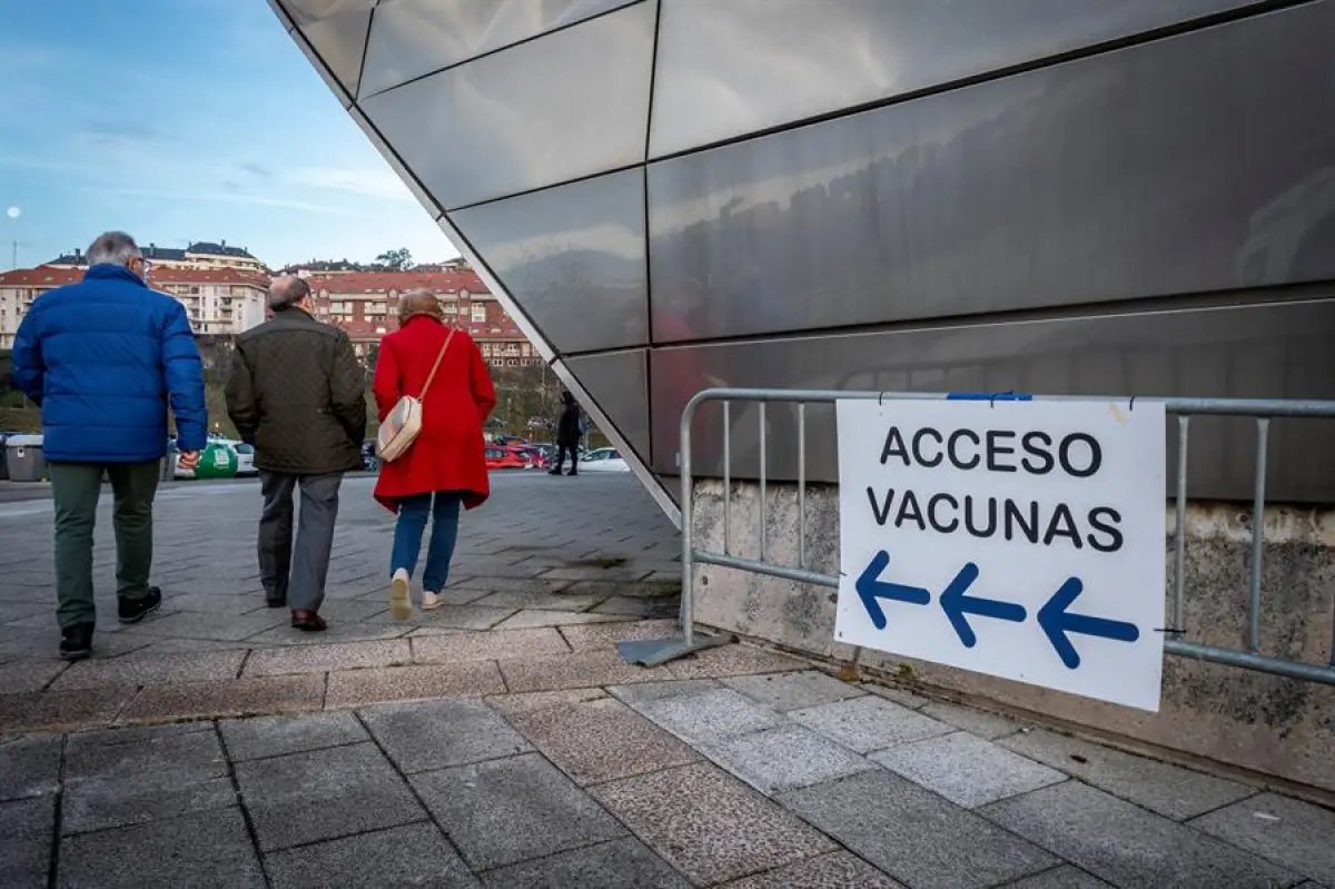  Tres personas caminan hacia un centro de vacunación contra el COVID-19 en Madrid. 
