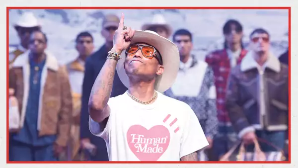 foto de pharrell williams, director creativo de louis vuitton, con una playera de corazón al centro que dice HUMAN MADE, levantndo el dedo meñique al cielo y usando un sombrero vaquero y unos lentes de sol.