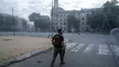 En esta fotografía de folleto tomada el 3 de julio de 2026 y publicada el 5 de julio de 2026 por el servicio de prensa de la 93a Brigada Mecanizada Separada de Kholodnyi Yar de las Fuerzas Terrestres de Ucrania, un servicio de servicio ucraniano camina por una calle cubierta con una red antidrones en Druzhkivka, región de Donetsk, en medio de la invasión rusa de Ucrania.