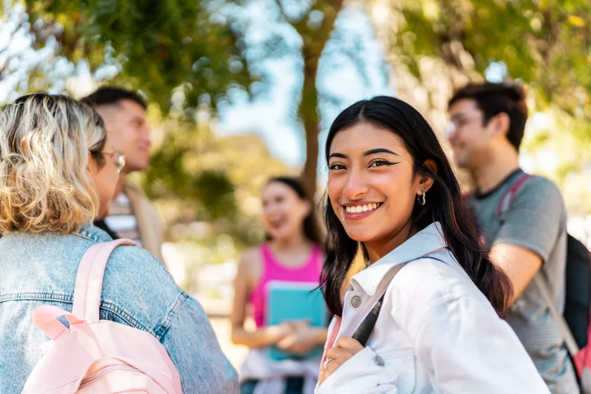 Portrait of a young woman with friends outdoors