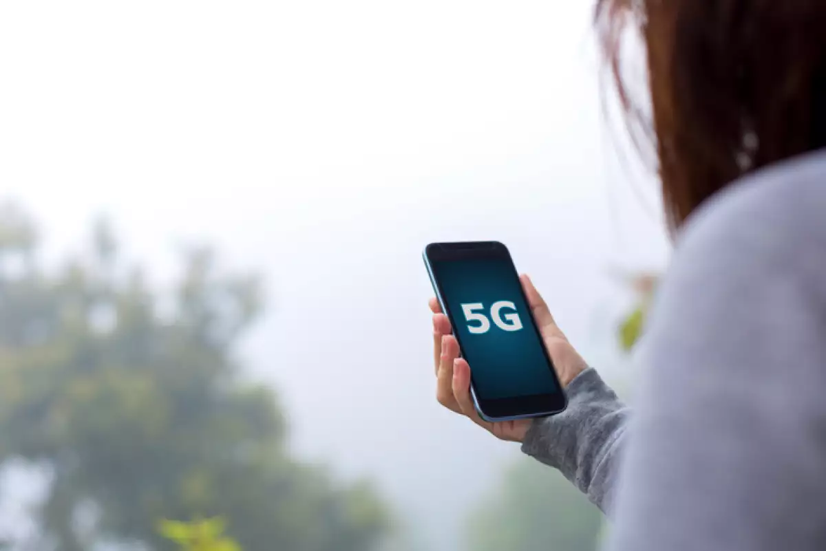 Young woman using 5G on smartphone